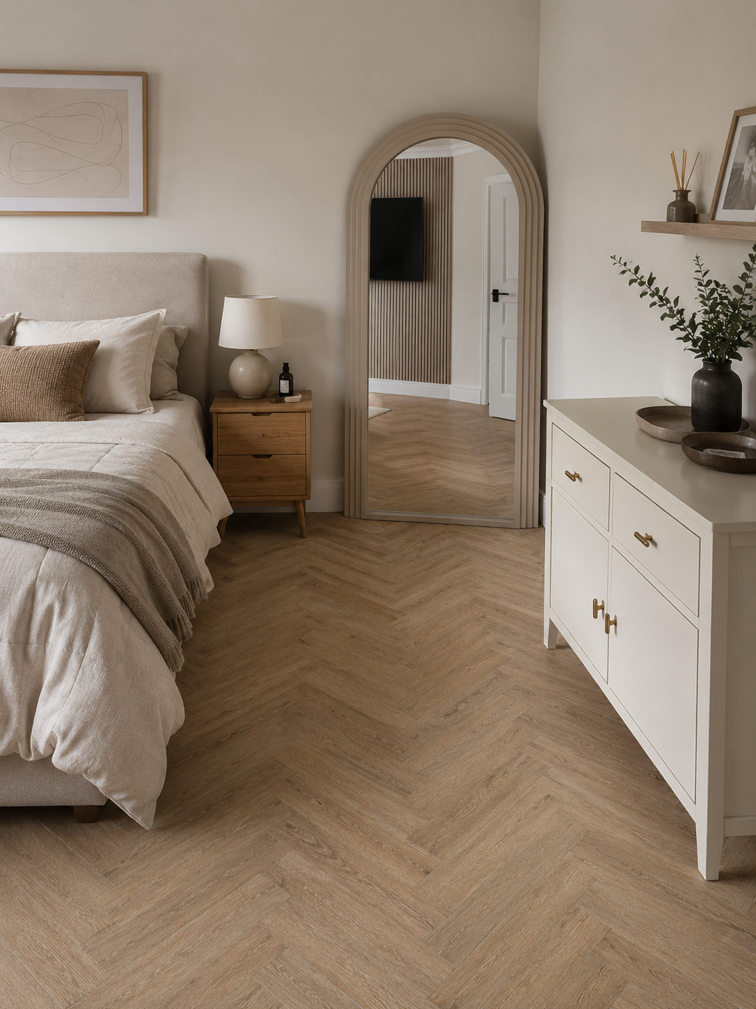 Amazon Oak Herringbone luxury vinyl flooring in a modern bedroom with realistic oak wood grain herringbone pattern, warm neutral décor, upholstered bed and contemporary interior styling.
