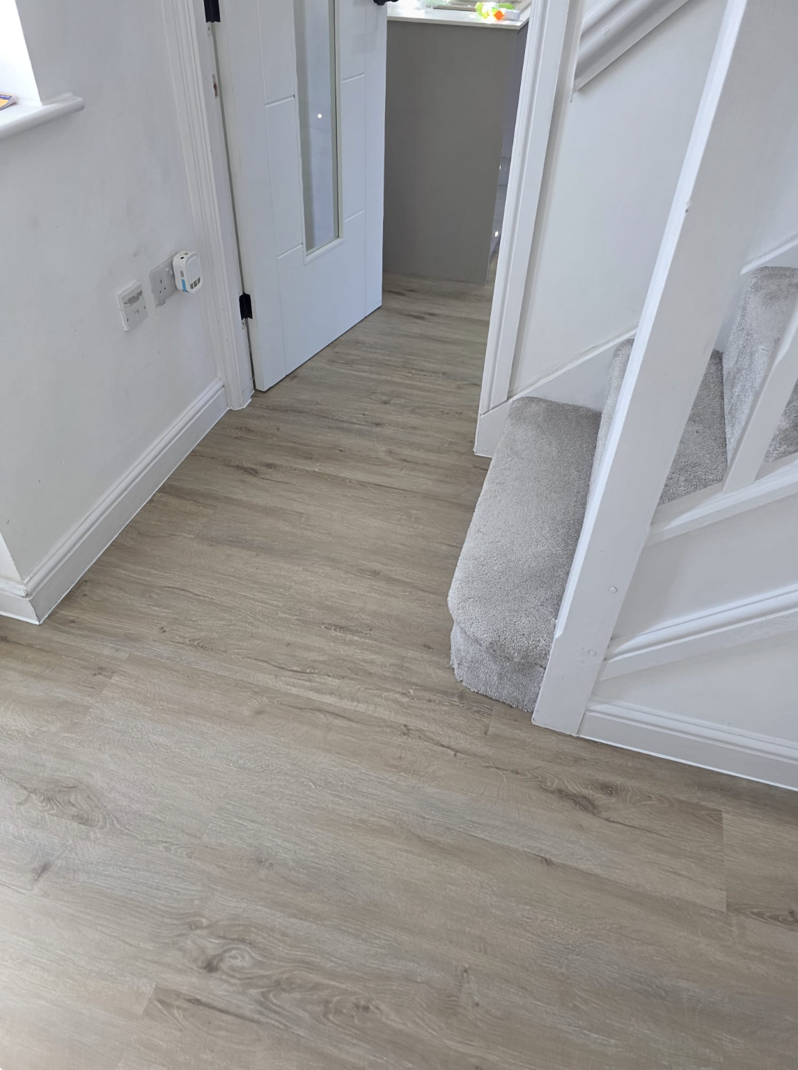 Amazon Oak SPC luxury vinyl flooring fitted in a customer home hallway, showcasing light oak plank flooring with realistic wood texture, waterproof performance and durable click-fit installation for busy family homes.