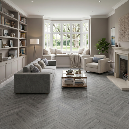 Azure Grey Herringbone Luxury Click Vinyl Flooring 5mm installed in a contemporary living room, featuring cool grey wood-effect herringbone SPC flooring with authentic grain, realistic knot detailing and a natural matt finish, creating a bright, elegant space with a large bay window, built-in shelving and modern neutral décor.