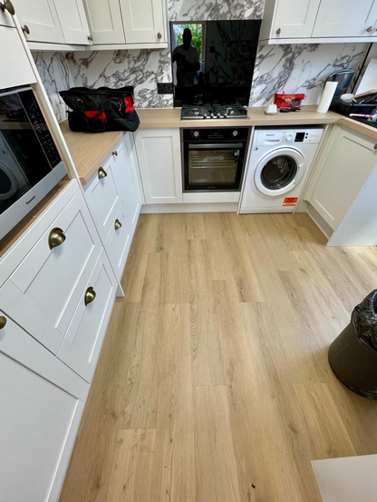 Keswick Oak SPC luxury vinyl flooring fitted in a customer kitchen, displaying light oak plank flooring with realistic wood grain, waterproof performance and easy-maintenance durability for busy households.