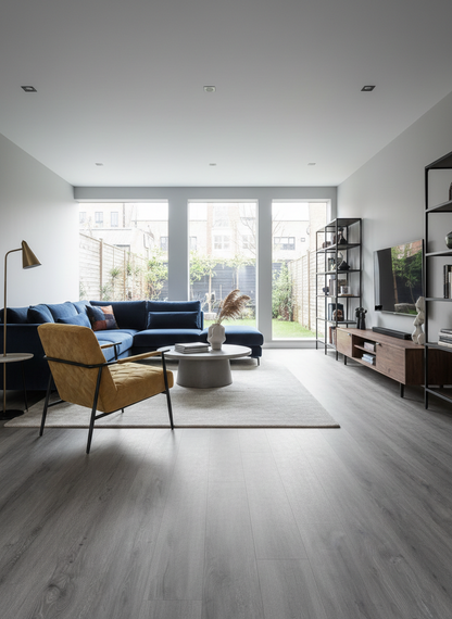 Azure Grey Luxury Click Vinyl Flooring 5mm installed in a contemporary open-plan living room, showcasing cool grey wood-effect planks with authentic grain detailing and a realistic matt finish, creating a bright, modern space with large patio doors and minimalist décor.